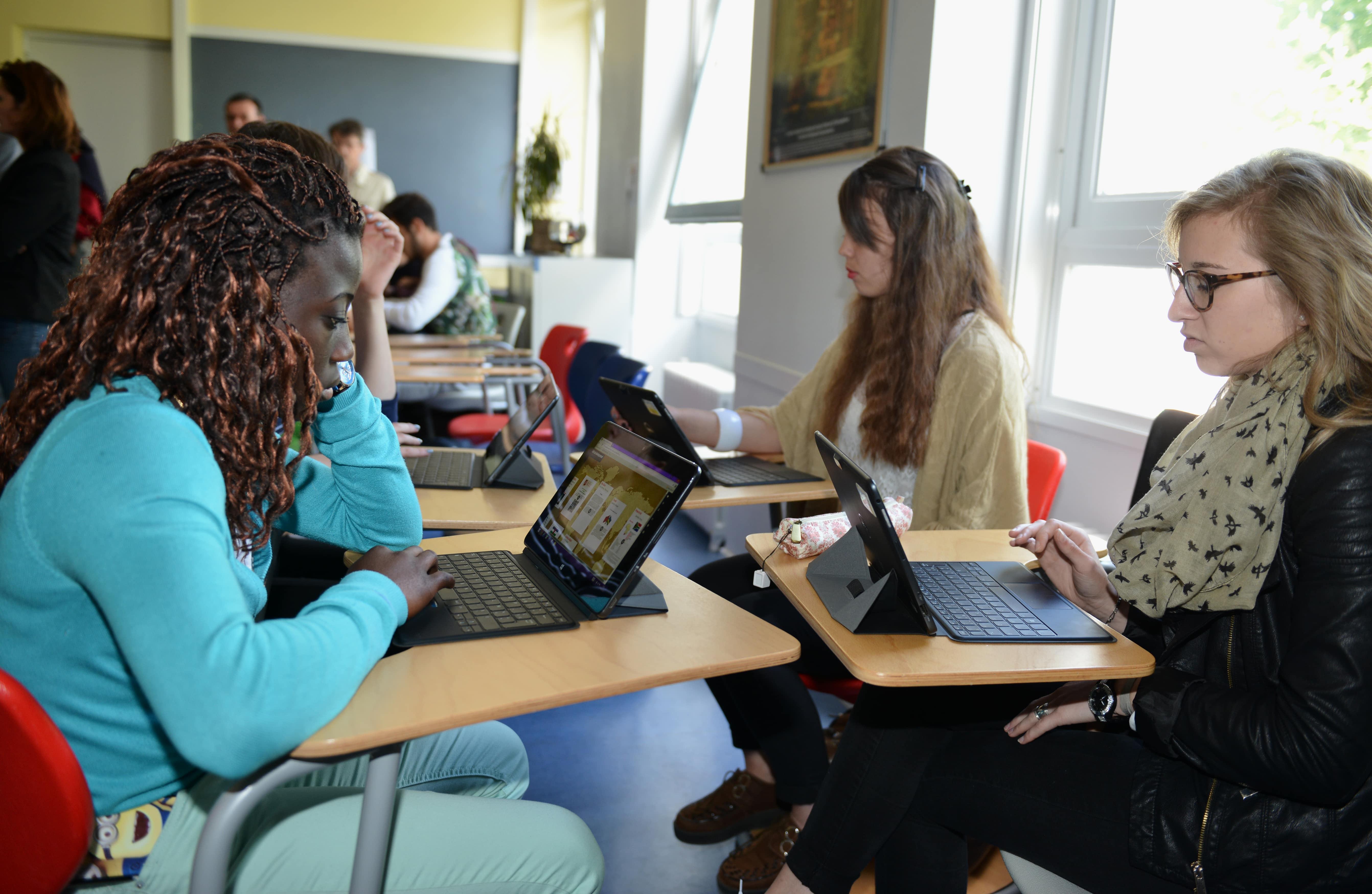Jeunes étudiant devant des tablettes